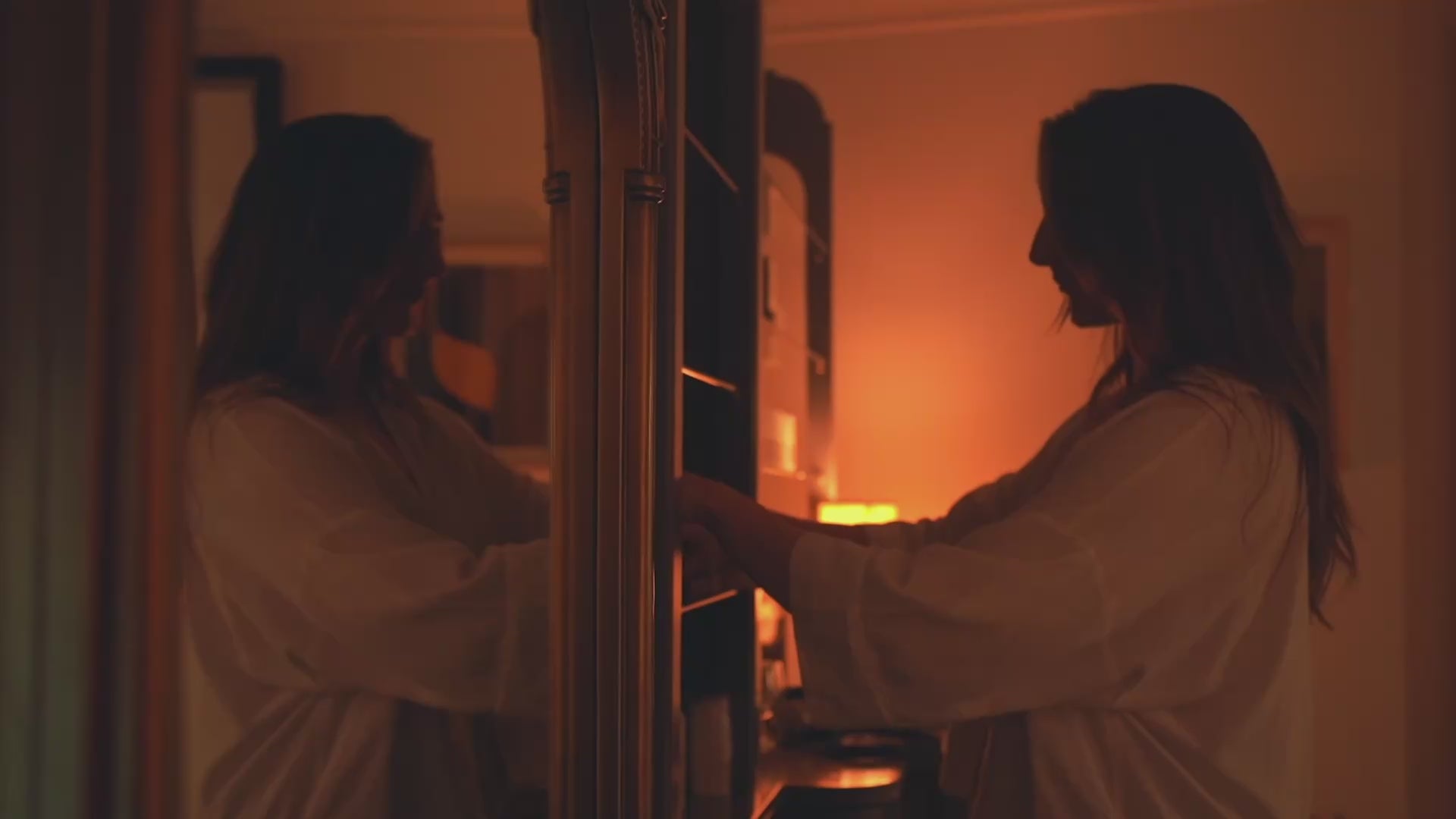 Katie England performing a facial treatment on a model in a dimly lit treatment room, montage video